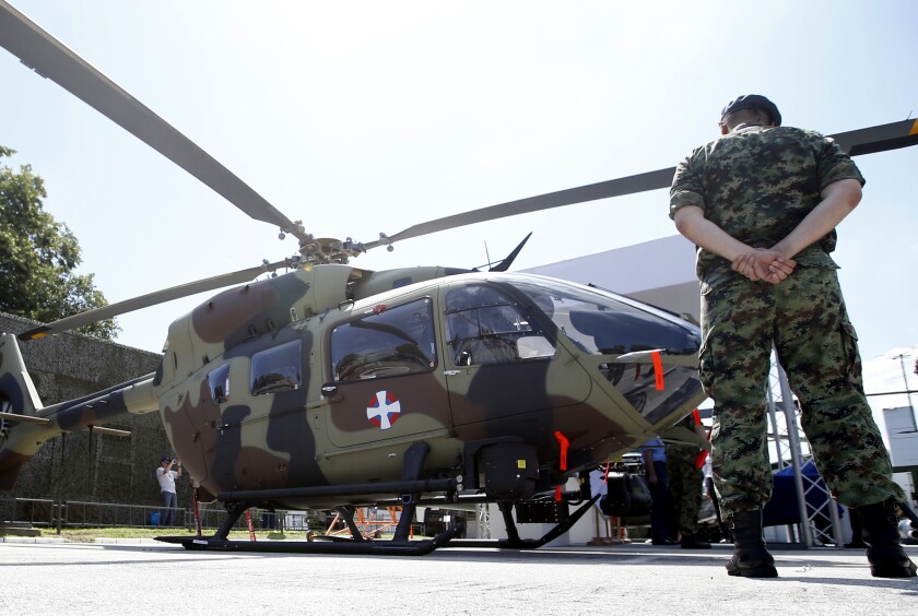 FILE - A Serbian Army officer stands by new Airbus H145M multi-utility helicopter during an arms fair in Belgrade, Serbia, Tuesday, June 25, 2019. Cyprus signed a deal with Airbus Helicopters on Friday, June 24, 2022 to purchase six light attack helicopters with an option for another six as it seeks to shed Soviet-era armaments and procure military equipment compatible with other European Union member states. (AP Photo/Darko Vojinovic, File)
