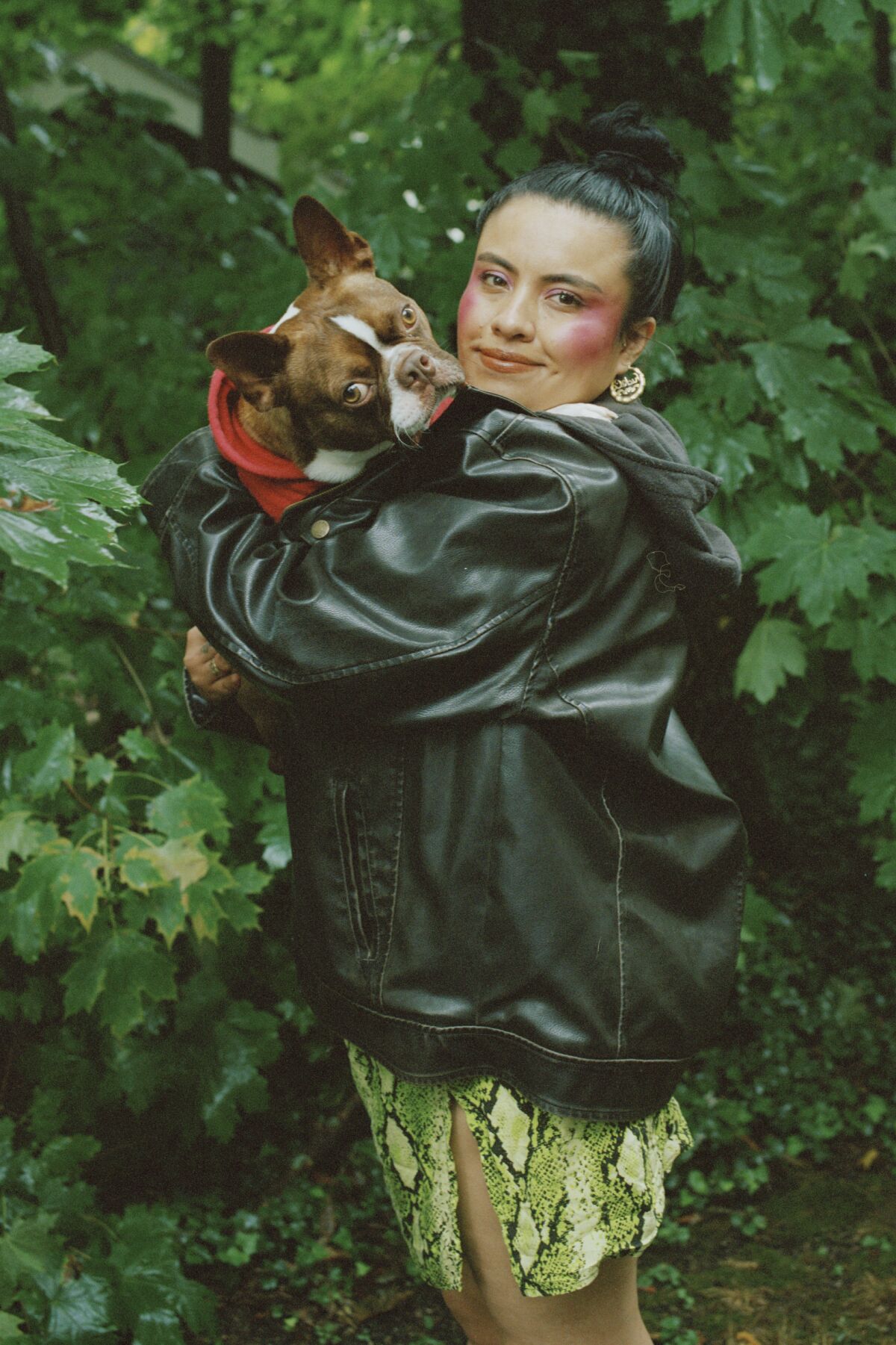 Writer Karla Cornejo Villavicencio holds a dog at her home in New Haven, Conn.