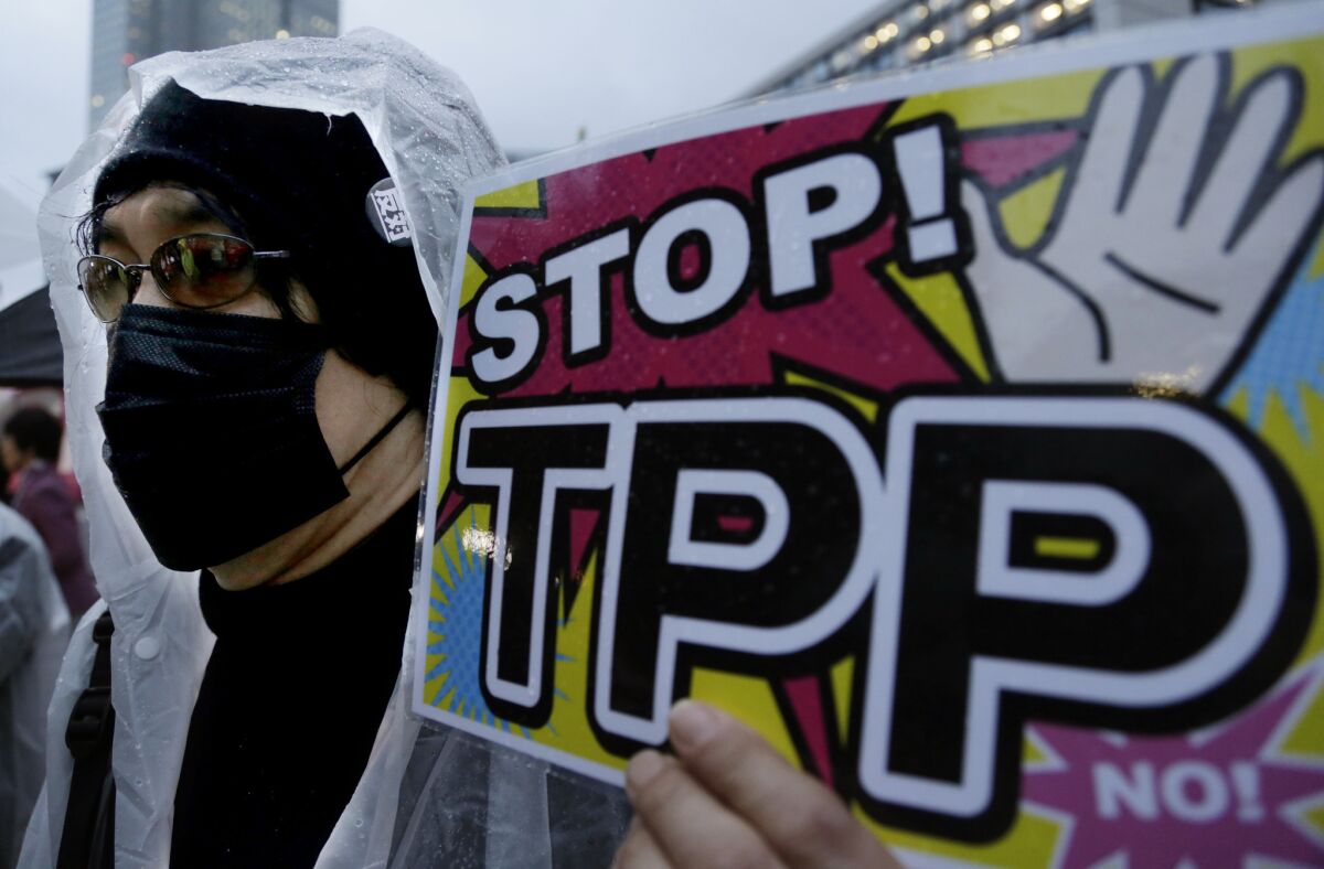 In this April 22, 2014 photo, a protester holds a placard during a rally against the Trans-Pacific Partnership (TPP) in Tokyo.