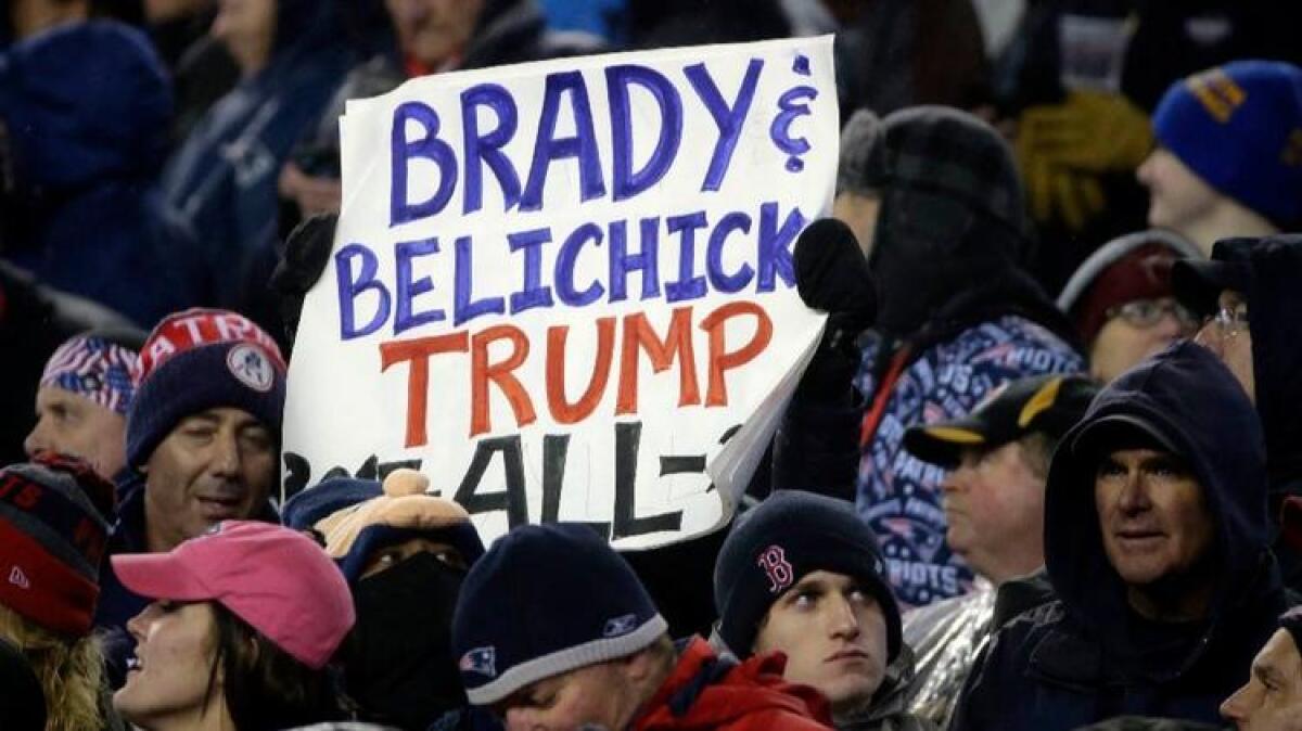 A Patriots fan holds a sign referring to Patriots quarterback Tom Brady, Coach Bill Belichick and President Trump during the AFC championship on Jan. 22.