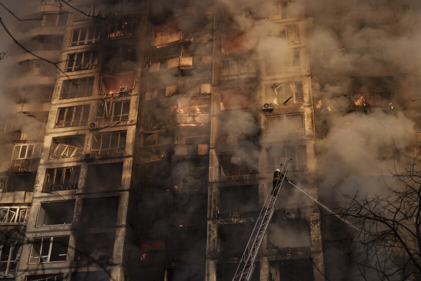 Firefighters extinguish flames in an apartment building after being hit by shelling in Kyiv, Ukraine, Tuesday, March 15, 2022. (AP Photo/Felipe Dana)