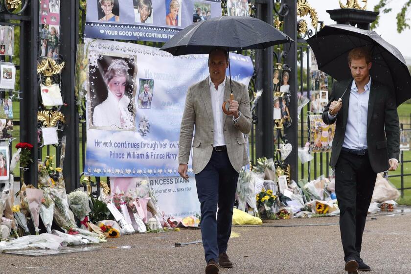 Britain's Prince William, Duke of Cambridge and Britain's Prince Harry walk away after looking at tributes left by members of the public at one of the entrances of Kensington Palace to mark the coming 20th anniversary of the death of Diana, Princess of Wales, in London on August 30, 2017. Princes William and Harry prepared to pay tribute to their late mother Princess Diana on Wednesday for the 20th anniversary of her death as wellwishers left candles and flowers outside the gates of her former London residence. The Princes visited the Sunken Garden in the grounds of Kensington Palace, which this year has been transformed into a White Garden, dedicated to their late mother, Britain's Diana, Princess of Wales. / AFP PHOTO / POOL / Kirsty WigglesworthKIRSTY WIGGLESWORTH/AFP/Getty Images ** OUTS - ELSENT, FPG, CM - OUTS * NM, PH, VA if sourced by CT, LA or MoD **