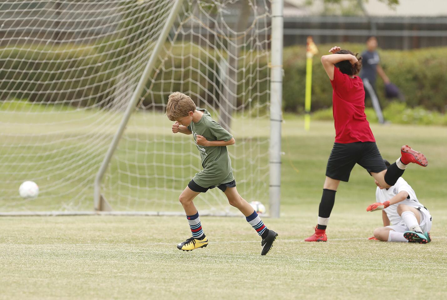 Mariners A's Tate Oyler, left, celebrates after scoring a goal on Whittier A's goalie Elliott Pena during a boys' fifth- and sixth-grade Gold Division game during the the Daily Pilot Cup on Tuesday, May 29.