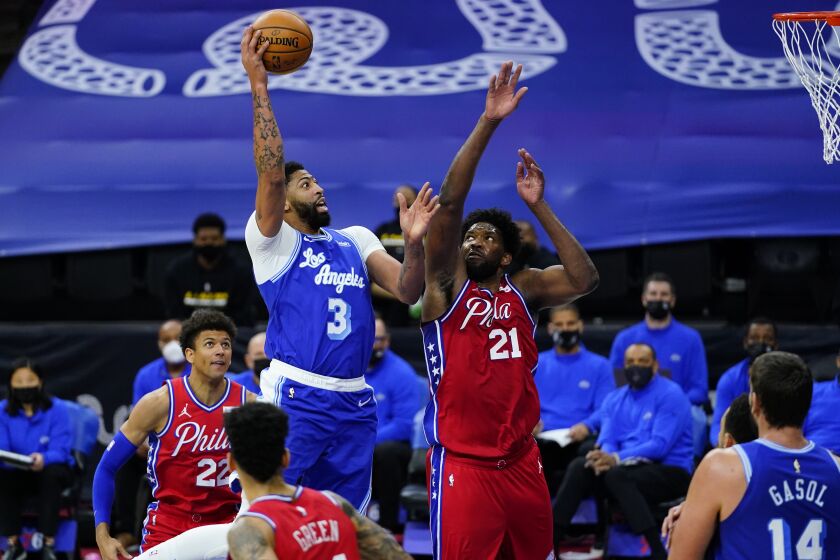 Los Angeles Lakers' Anthony Davis (3) goes up for a shot against Philadelphia 76ers' Joel Embiid (21) during the first half of an NBA basketball game, Wednesday, Jan. 27, 2021, in Philadelphia. (AP Photo/Matt Slocum)