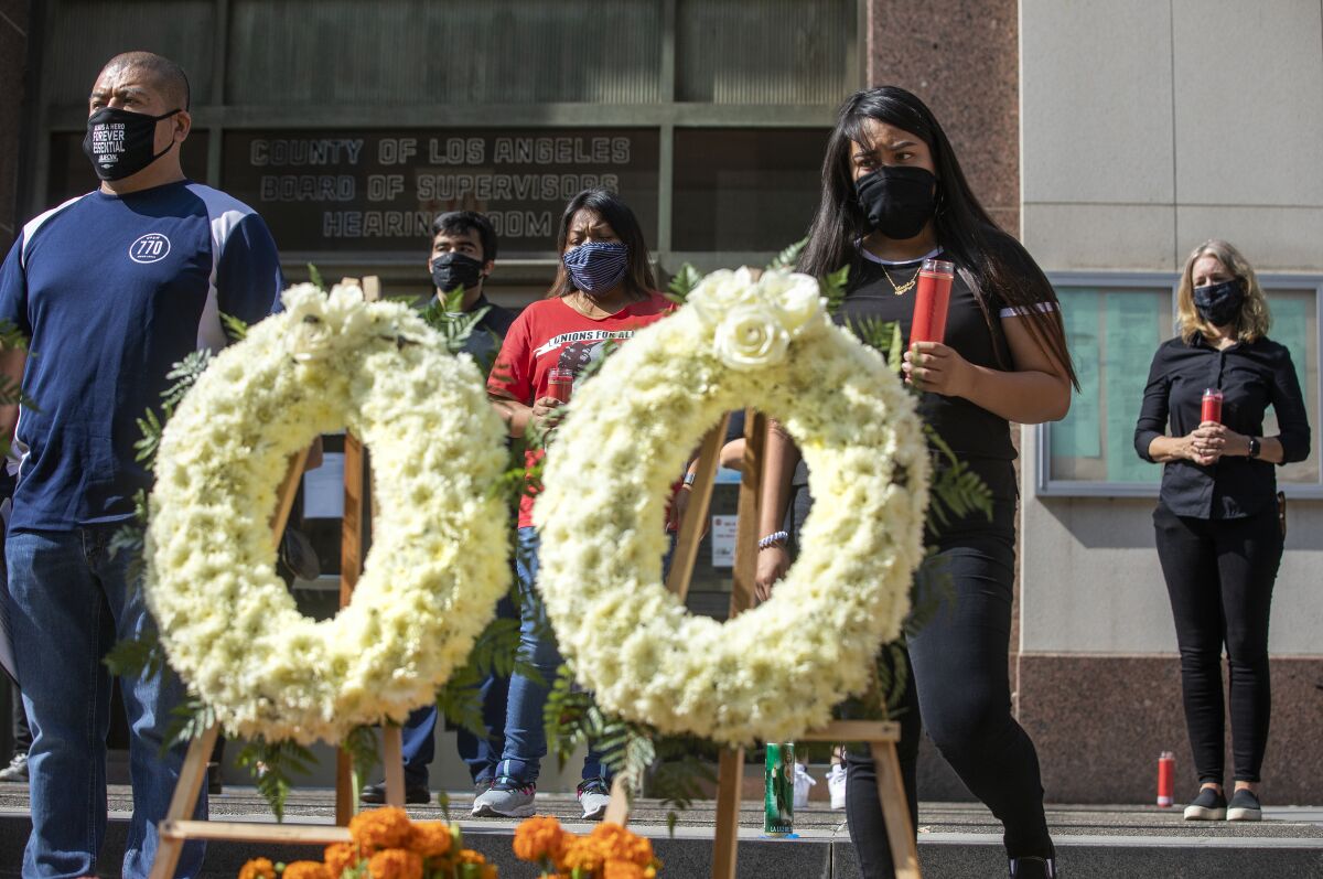 Overhill Farms workers take part in a memorial in downtown Los Angeles to honor those who have died of COVID-19.