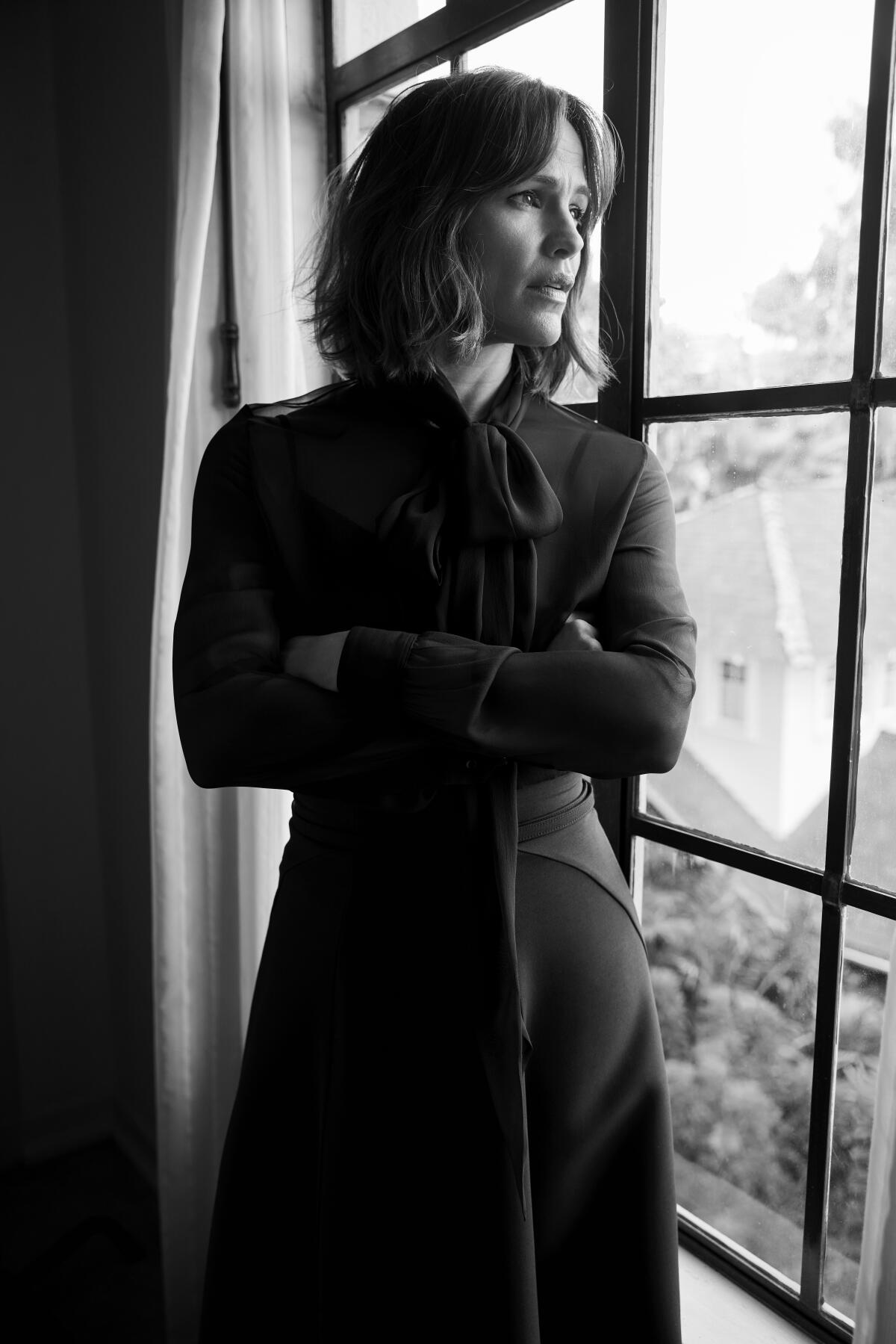 Jennifer Garner looks out a window in a black and white portrait.