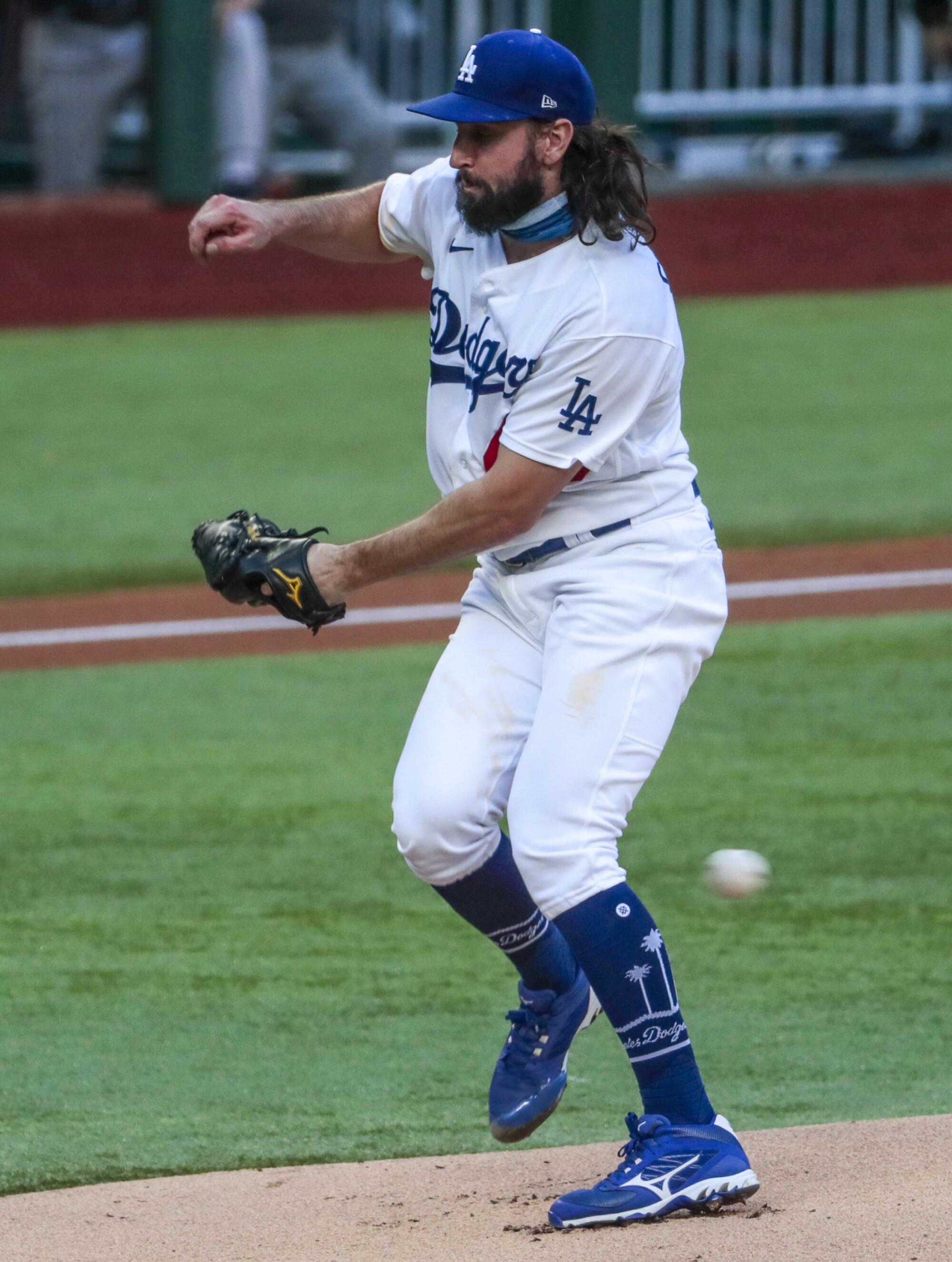 Dodgers starting pitcher Tony Gonsolin avoids a comebacker hit by Atlanta's Marcell Ozuna during the first inning.