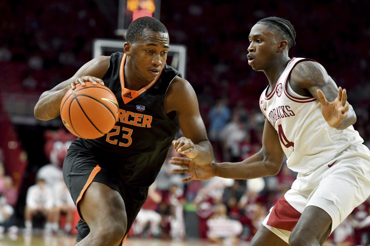 Mercer forward James Glisson III (23) tries to drive past Arkansas guard Davonte Davis (4) during the second half of an NCAA college basketball game Tuesday Nov. 9, 2021, in Fayetteville, Ark. (AP Photo/Michael Woods)