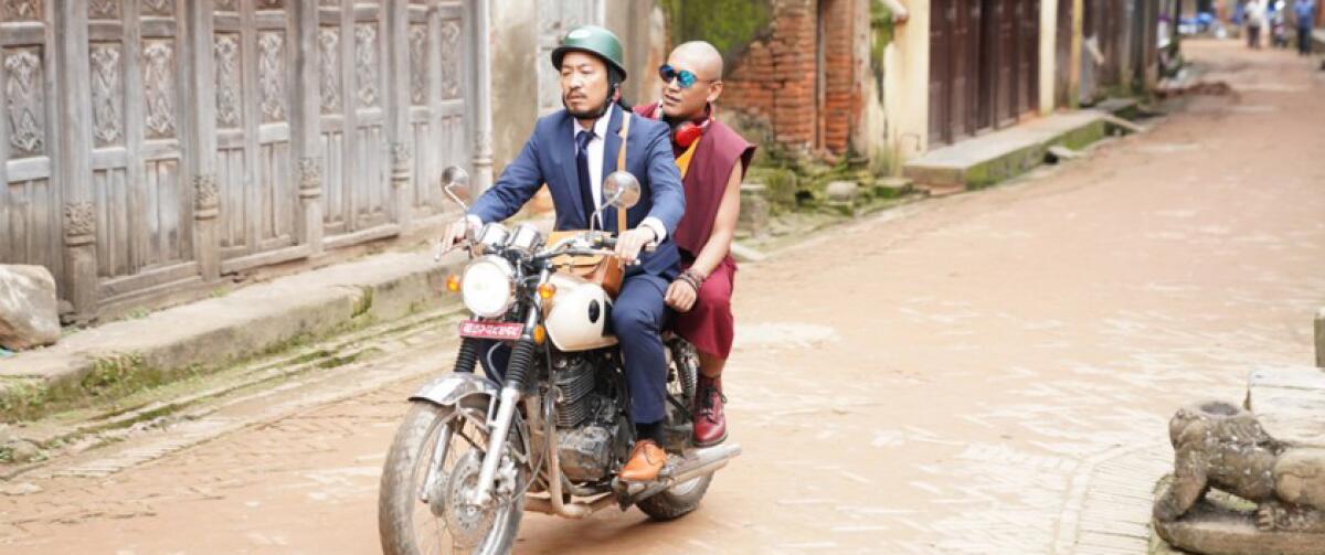 Two actors on a motorbike in the movie “Looking for a Lady With Fangs and a Moustache.”