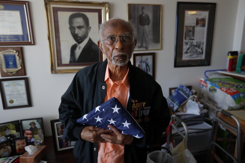 World War II veteran Johnnie Jones, Sr. poses for a portrait at his home in Baton Rouge, La., Tuesday, May 28, 2019. Jones, who joined the military in 1943 out of Southern University in Baton Rouge, was a warrant officer in a unit responsible for unloading equipment and supplies onto Normandy. He remembers wading ashore and one incident when he and his fellow soldiers came under fire from a German sniper. He grabbed his weapon and returned fire along with the other soldiers. It's something that still haunts his memories. (AP Photo/Gerald Herbert)