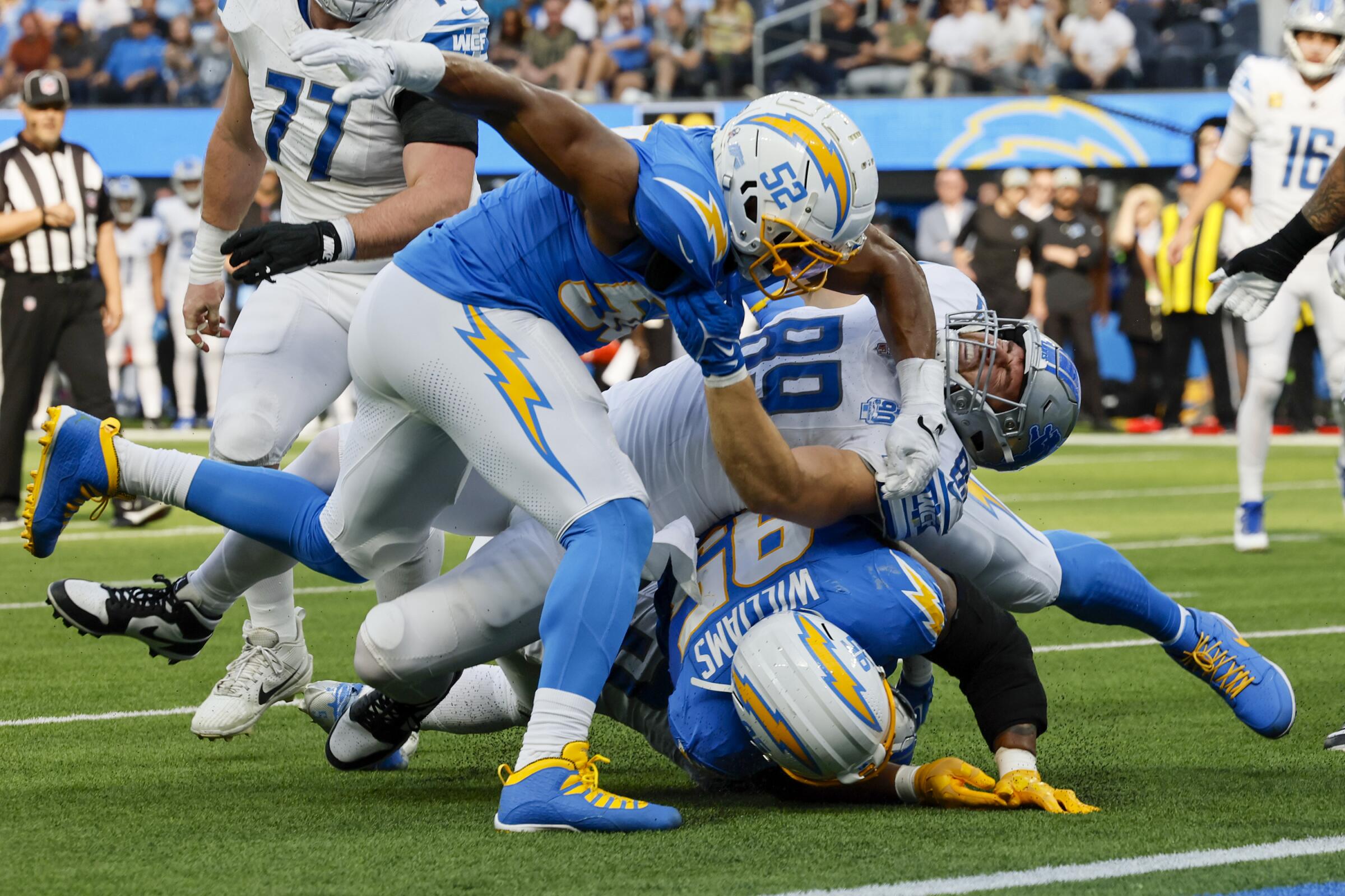 Chargers linebacker Khalil Mack and defensive tackle Nick Williams stop Detroit Lions running back David Montgomery.