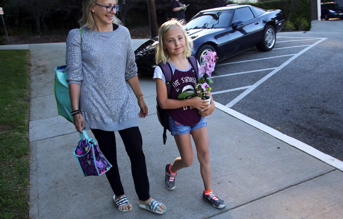 Palm Crest Elementary School fourth-grader Juliet Brown is all smiles as she walks into the school's campus on the first day of the school year Thursday.