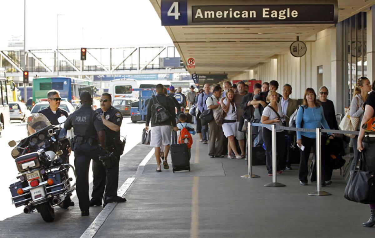 Los Angeles Airport Police officers meet in front of American Airlines check-in line at Terminal 4 at LAX.