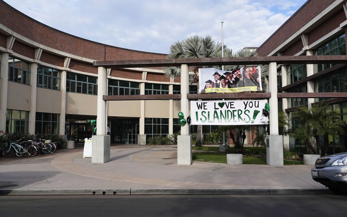 A sign reads "We love you Islanders!" at the Coronado High School campus