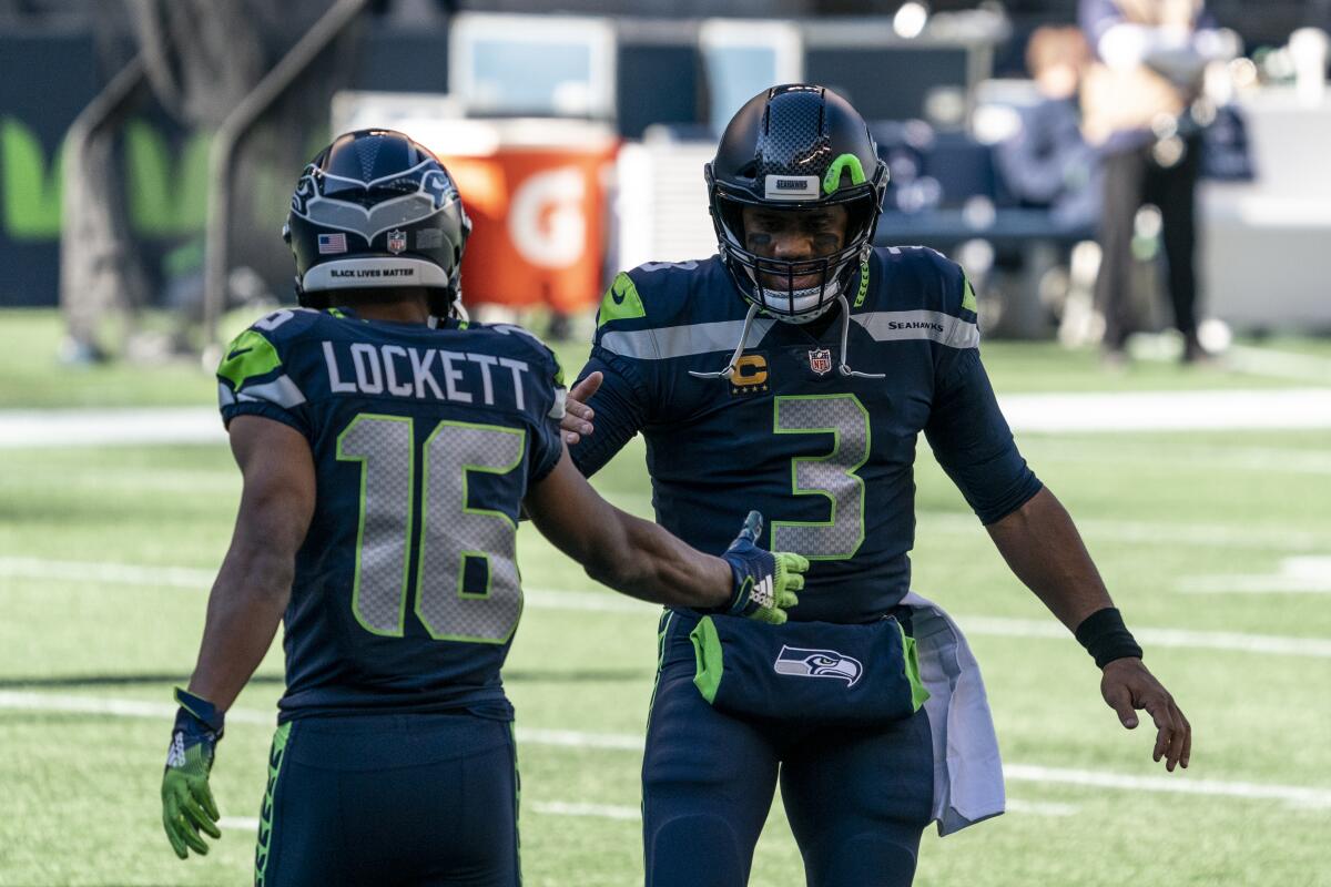 Seattle Seahawks quarterback Russell Wilson greets wide receiver Tyler Lockett.