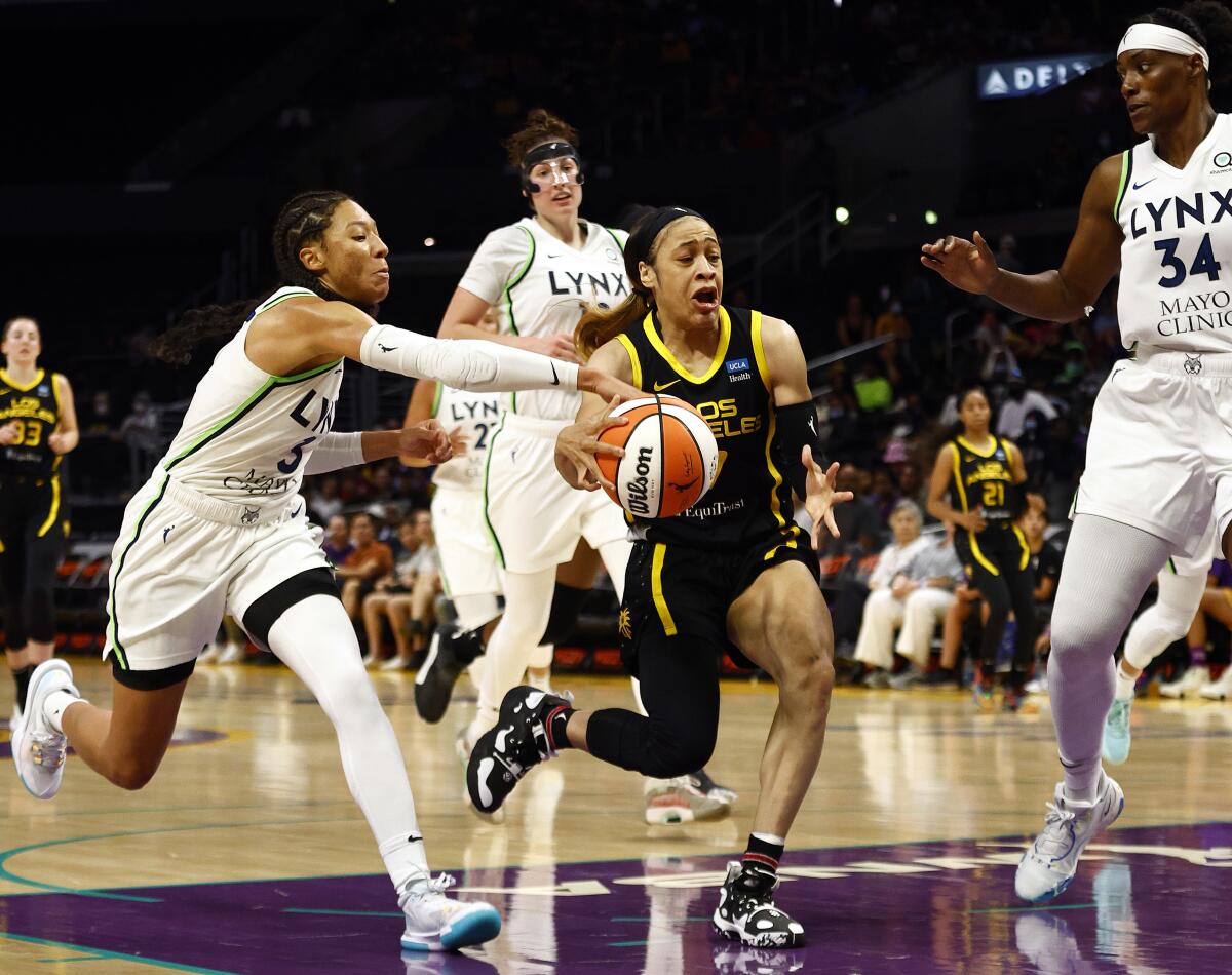 Sparks guard Chennedy Carter controls the ball in front of Minnesota Lynx small forward Aerial Powers.