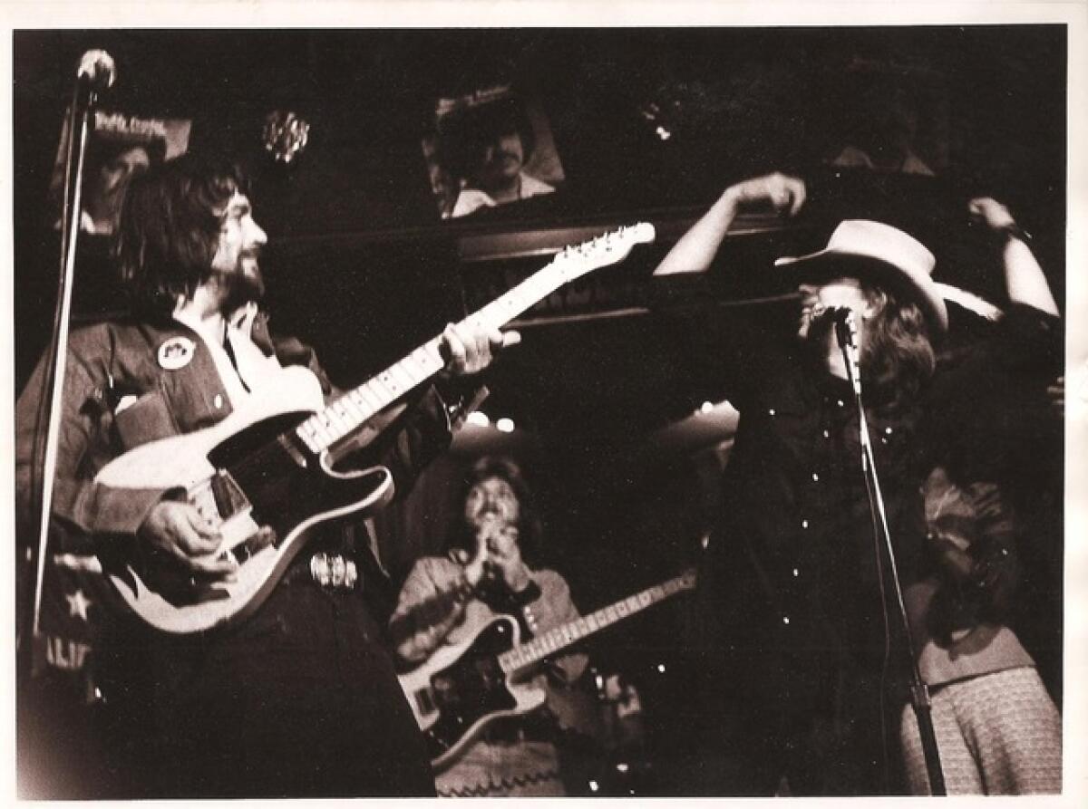 Waylon Jennings and Jimmy Rabbitt perform onstage.