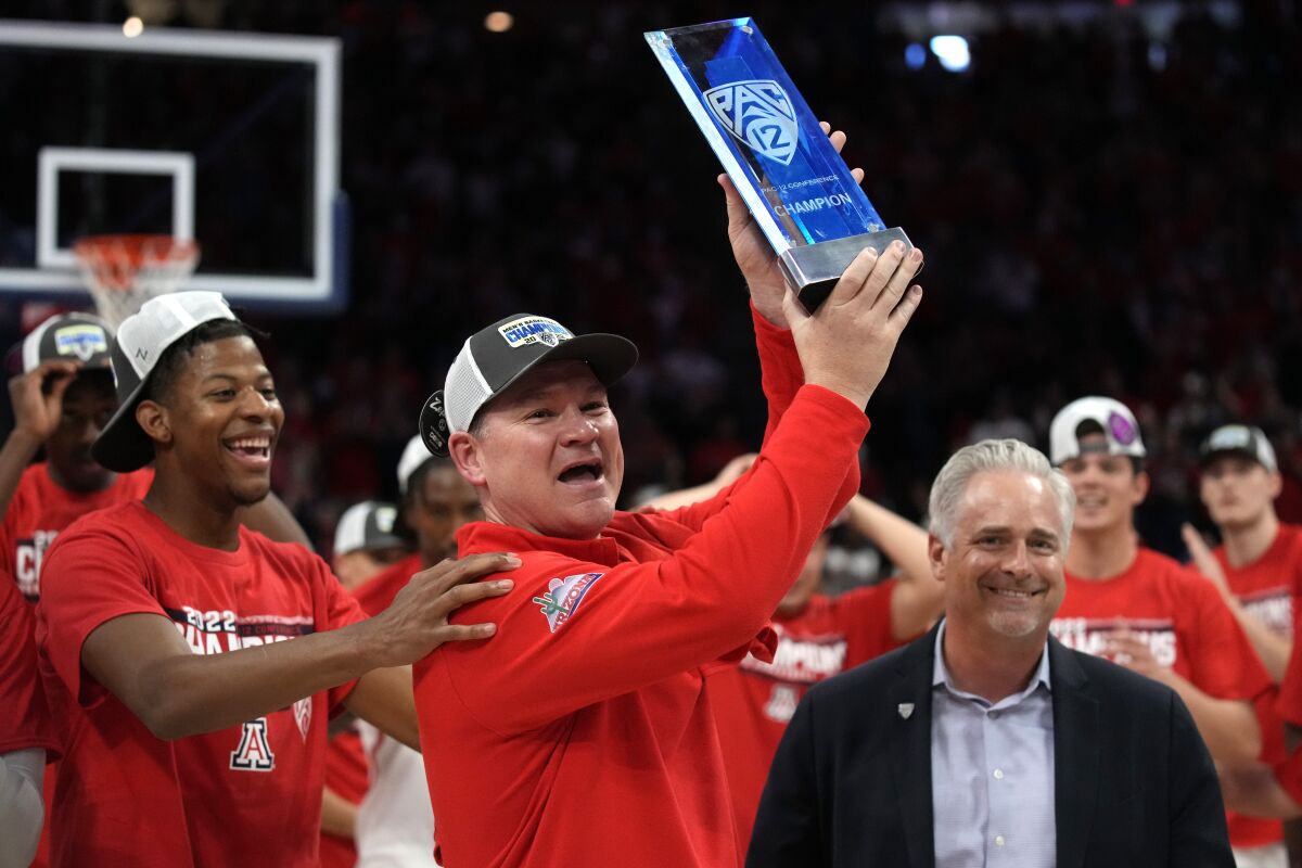 Arizona head coach Tommy Lloyd holds up the the Pac-12 Conference Championship trophy after an NCAA college basketball game against California, Saturday, March 5, 2022, in Tucson, Ariz. (AP Photo/Rick Scuteri)