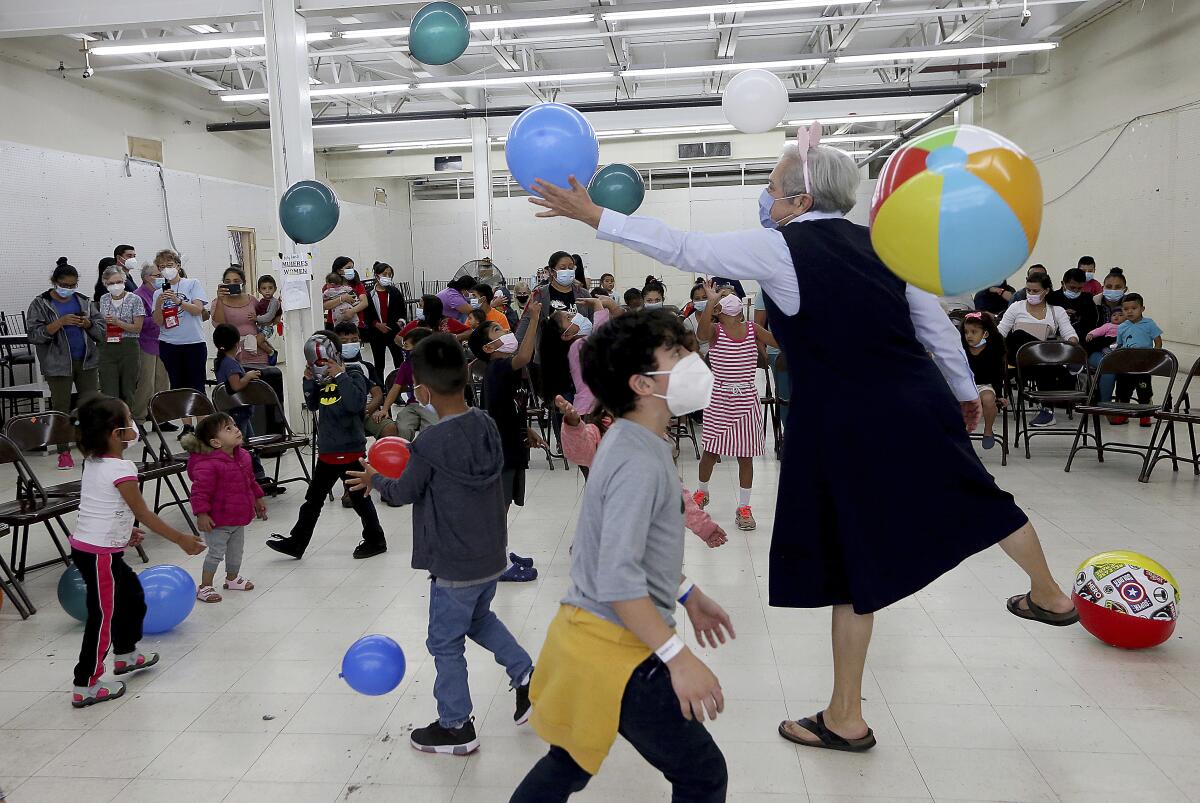 Sister Norma Pimentel reaches for a balloon as children play around her during Children's Day