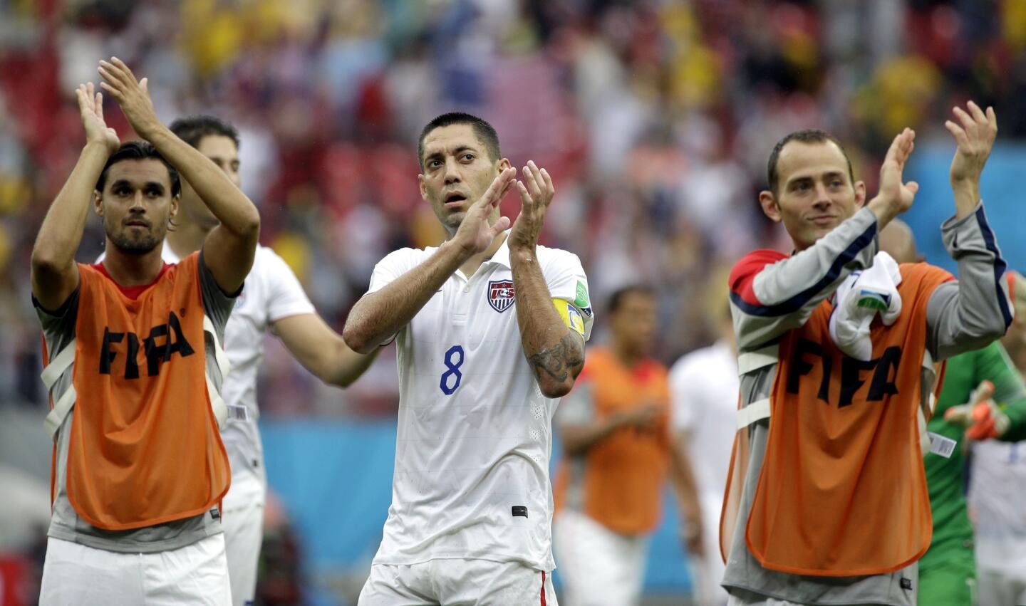 U.S. forward Clint Dempsey, center, celebrates with his teammates after advancing to the Round of 16 at the World Cup. The U.S. advanced despite the team's 1-0 loss to Germany in their final match of Group G play.