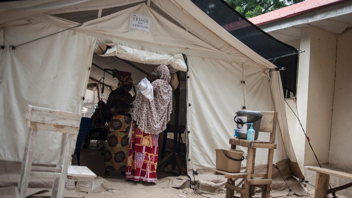 A woman and her baby arrive at the In-Patient Therapeutic Feeding Center in the Gwangwe district of Maiduguri, Nigeria.