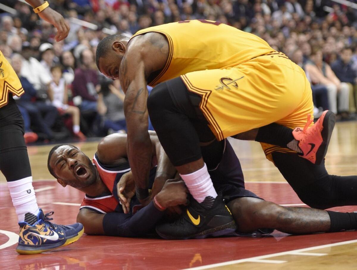 Cavaliers forward LeBron James, top, battles for the ball against Wizards guard John Wall, bottom, during the second half on Feb. 6.