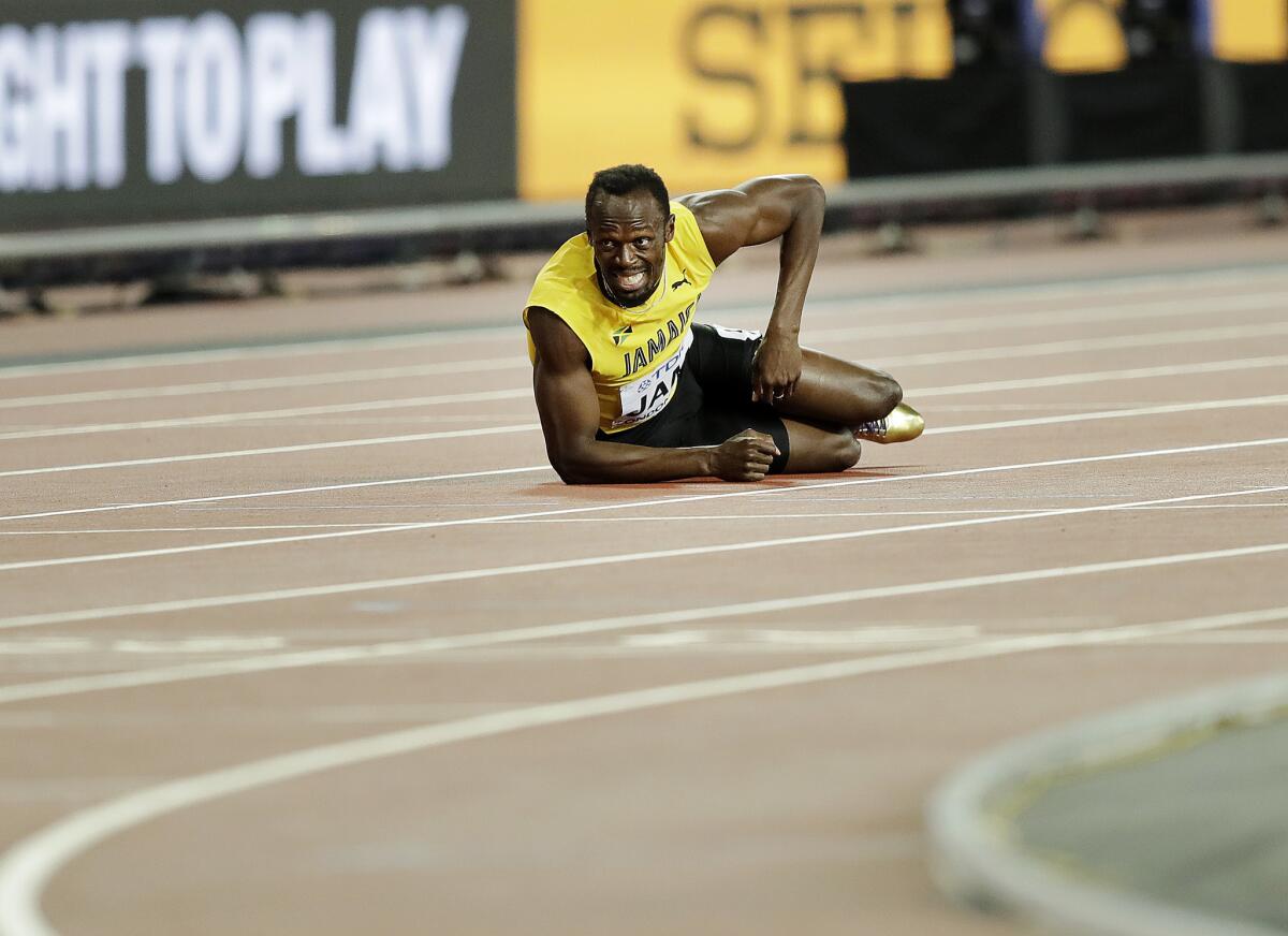 ARCHIVO - En esta foto del 12 de agosto de 2017, el velocista jamaiquino Usain Bolt aparece tirado en el suelo tras lesionarse en la final de los 4x100 metros en el Mundial de Atletismo en Londres.