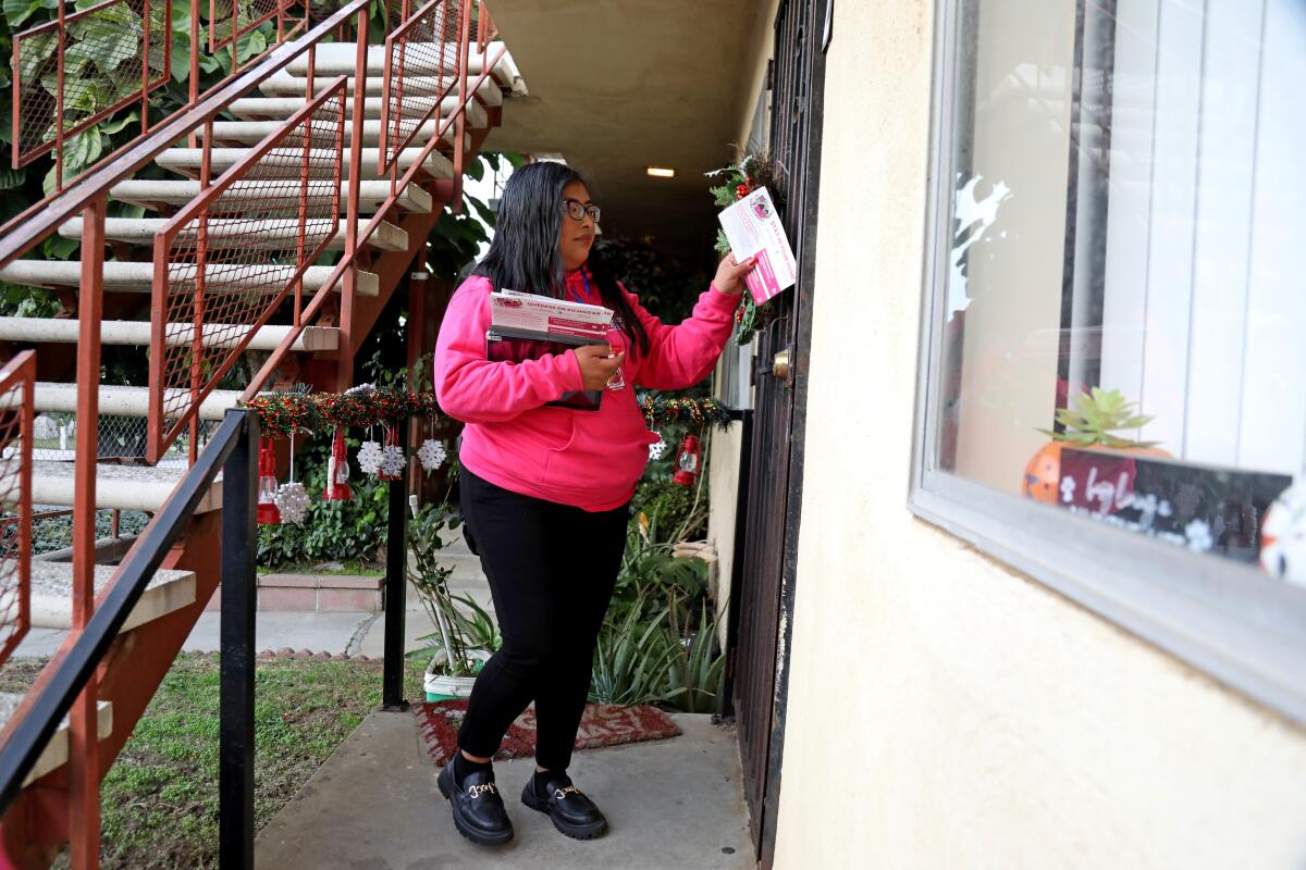 Bianca Lopez drops of flyers at an apartment complex in Los Angeles. 