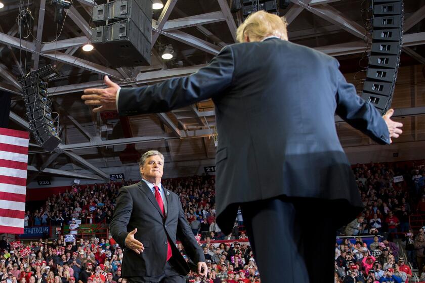 Donald Trump greets talk show host Sean Hannity at a Make America Great Again rally in Cape Girardeau, Missouri on November 5, 2018.