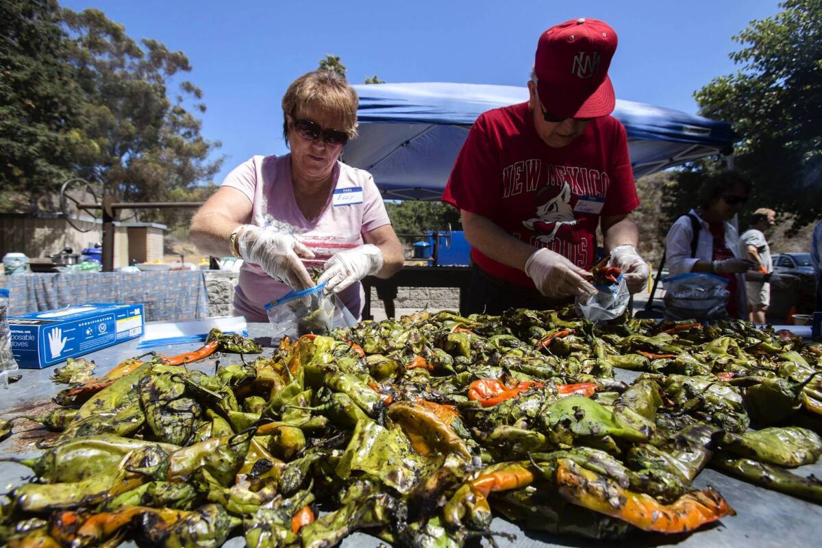 Elly Cleary and her husband, Bill, fill plastic bags with roasted chiles during the 20th annual Green Chile Roast & Lunch at Arroyo Verde Park in Ventura.