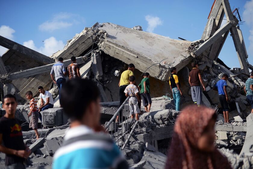 Palestinian boys walk on the bombed out remains of a mosque that was targeted by Israeli airstrikes in Nuseirat, central Gaza.