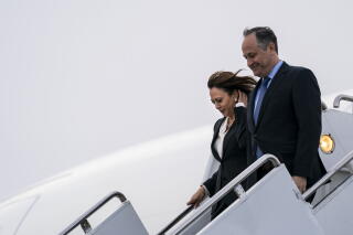 Kamala Harris and Second Gentleman Doug Emhoff depart a plane onto stairs