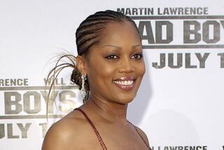 Theresa Randle with her hair braided and in a bun in a sparking, stringy gown. 