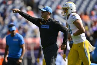  Jim Harbaugh points instructions to the Chargers as  Justin Herbert (10) jogs onto the field in Denver.