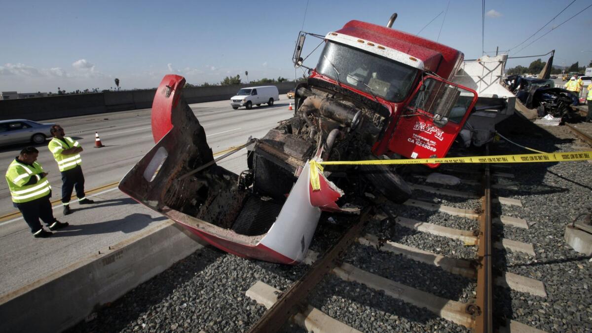 Crews work at the scene of a collision between a car, a big rig and a pickup truck on the eastbound 210 Freeway in Pasadena in 2010. The accident shut down the Metro Gold Line after two of the vehicles ended up on the tracks.