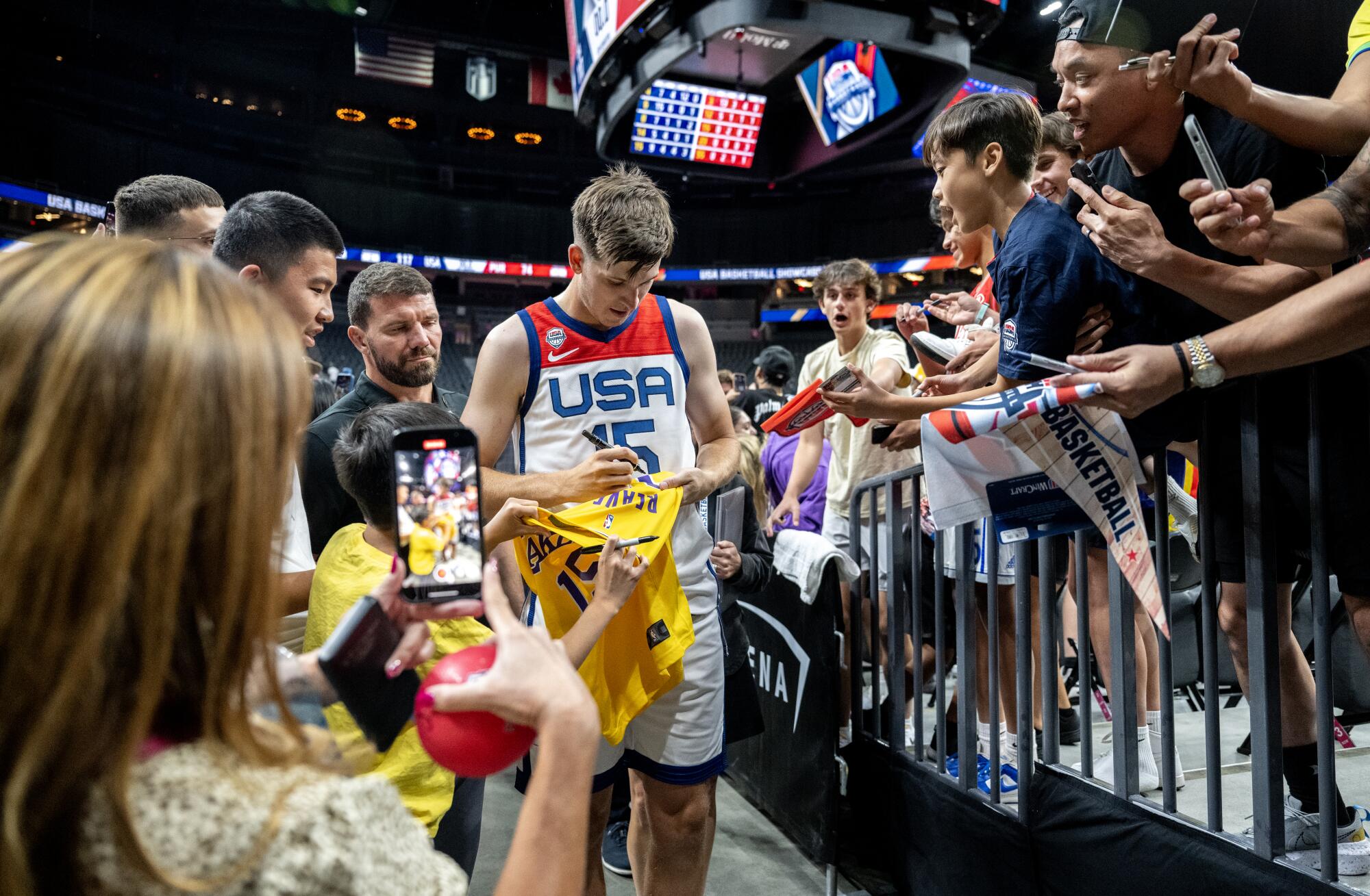 Team USA guard Austin Reaves signs a fan's Lakers jersey while leaving the court after an exhibition game in Las Vegas.