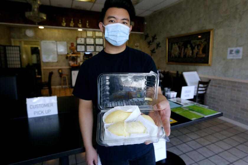 Bangkok Taste Restaurant co-owner Chris Meechukant shows a box of the $35 Durian sold a this restaurant on the 2700 block of N. Grand Ave., in Santa Ana on Wednesday, Aug. 5, 2020. Meechukant said he sells about 48 of the 2-3 piece boxes per week. The restaurant began selling the Thailand-imported fruit about one month ago and his deliveries have gone as far as Laguna Hills.