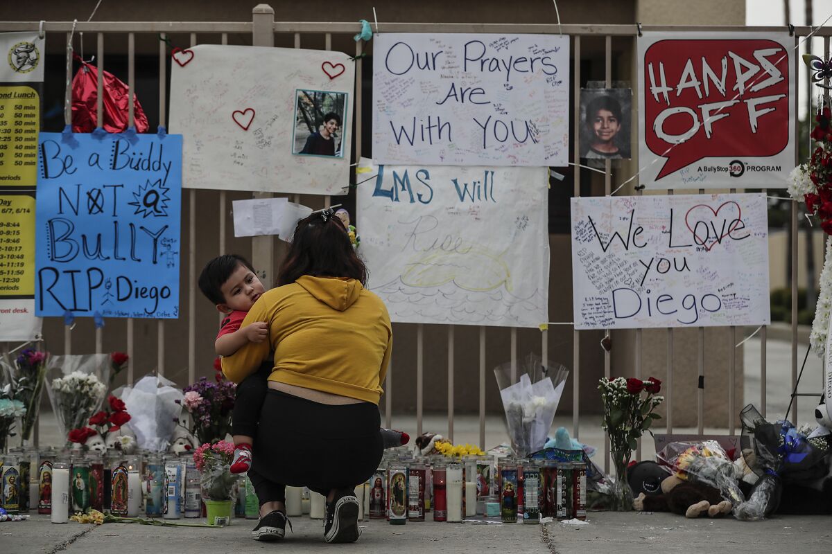 Vivian Ortiz and her son visit a memorial to a student at Landmark Middle School in Moreno Valley on Sept. 26, 2019.