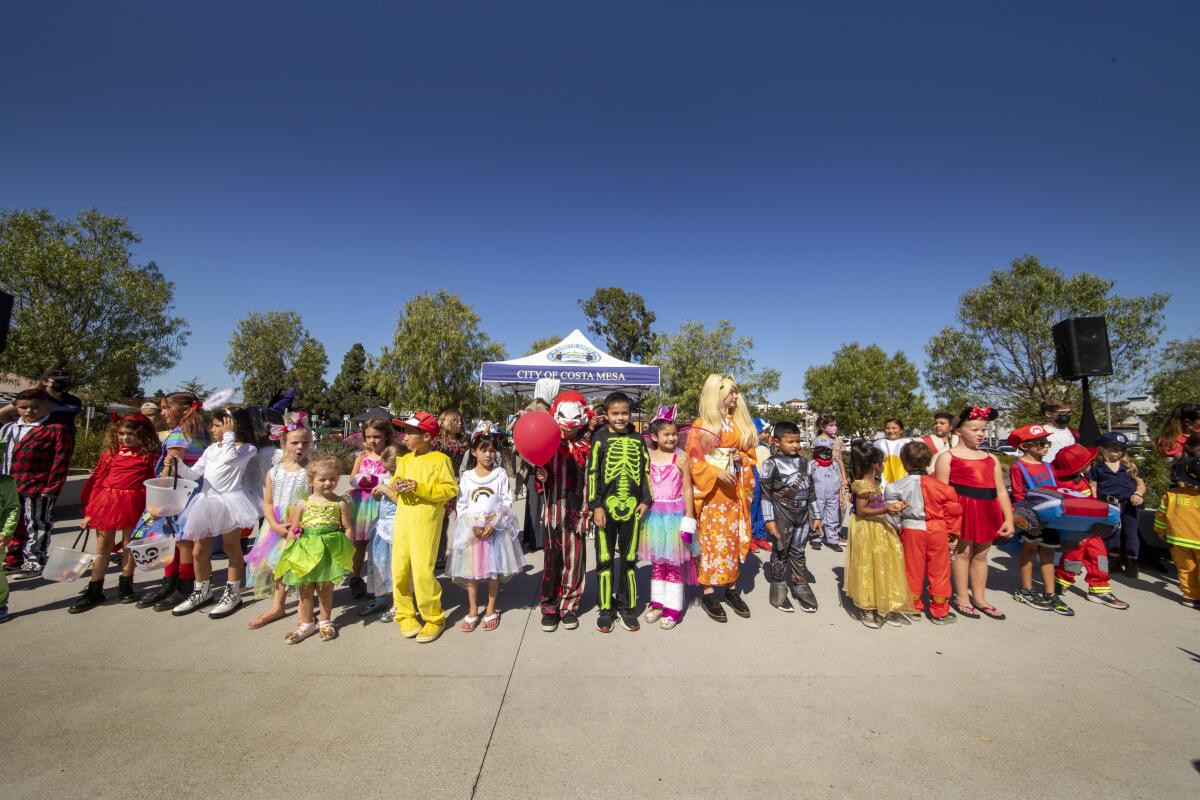 Participants in a kids costume parade pose for a photo at Lions Park in Costa Mesa. 