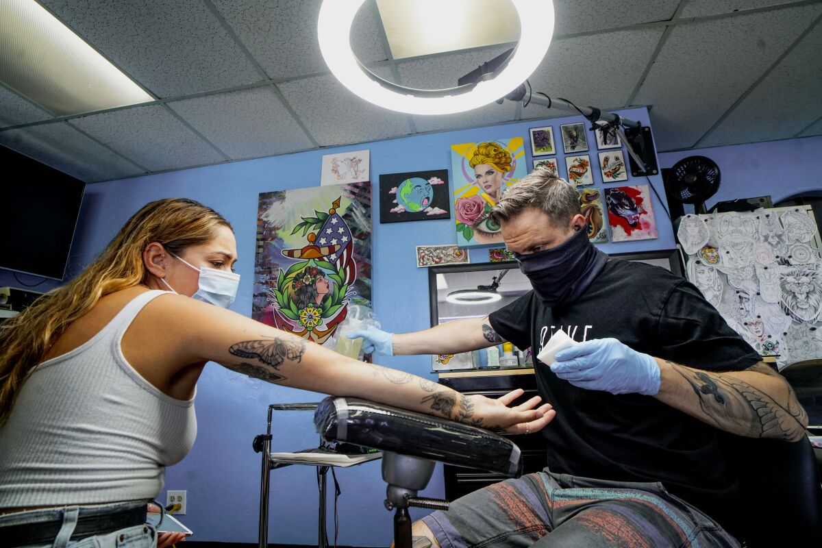 Eric Whitman works on a tattoo.