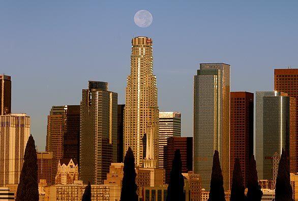 A full moon sets over the U.S. Bank Tower in downtown Los Angeles this morning. Calm winds have brought relief to beleaguered firefighters and homeowners.