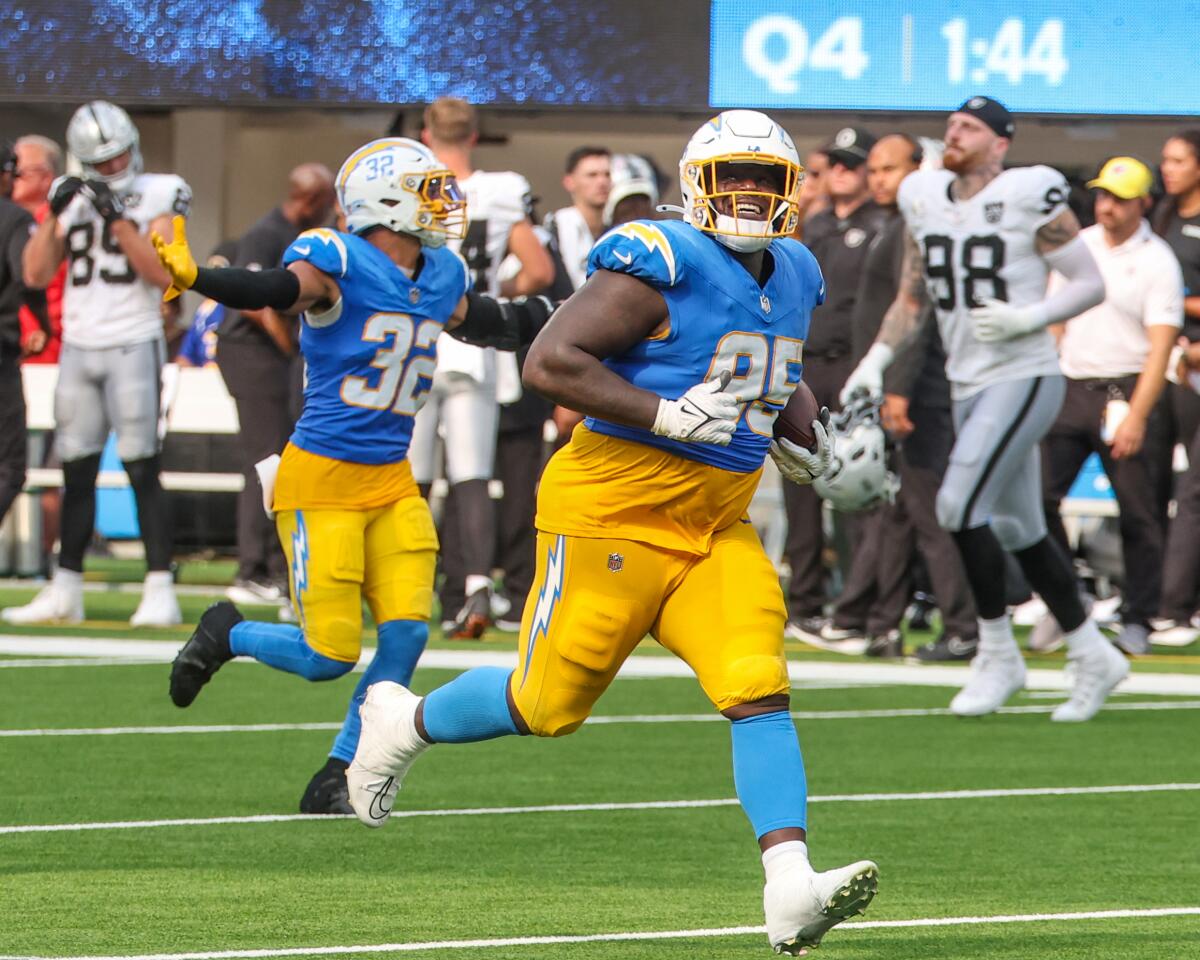 Chargers defensive tackle Poona Ford (95) celebrates after his interception against the Raiders.