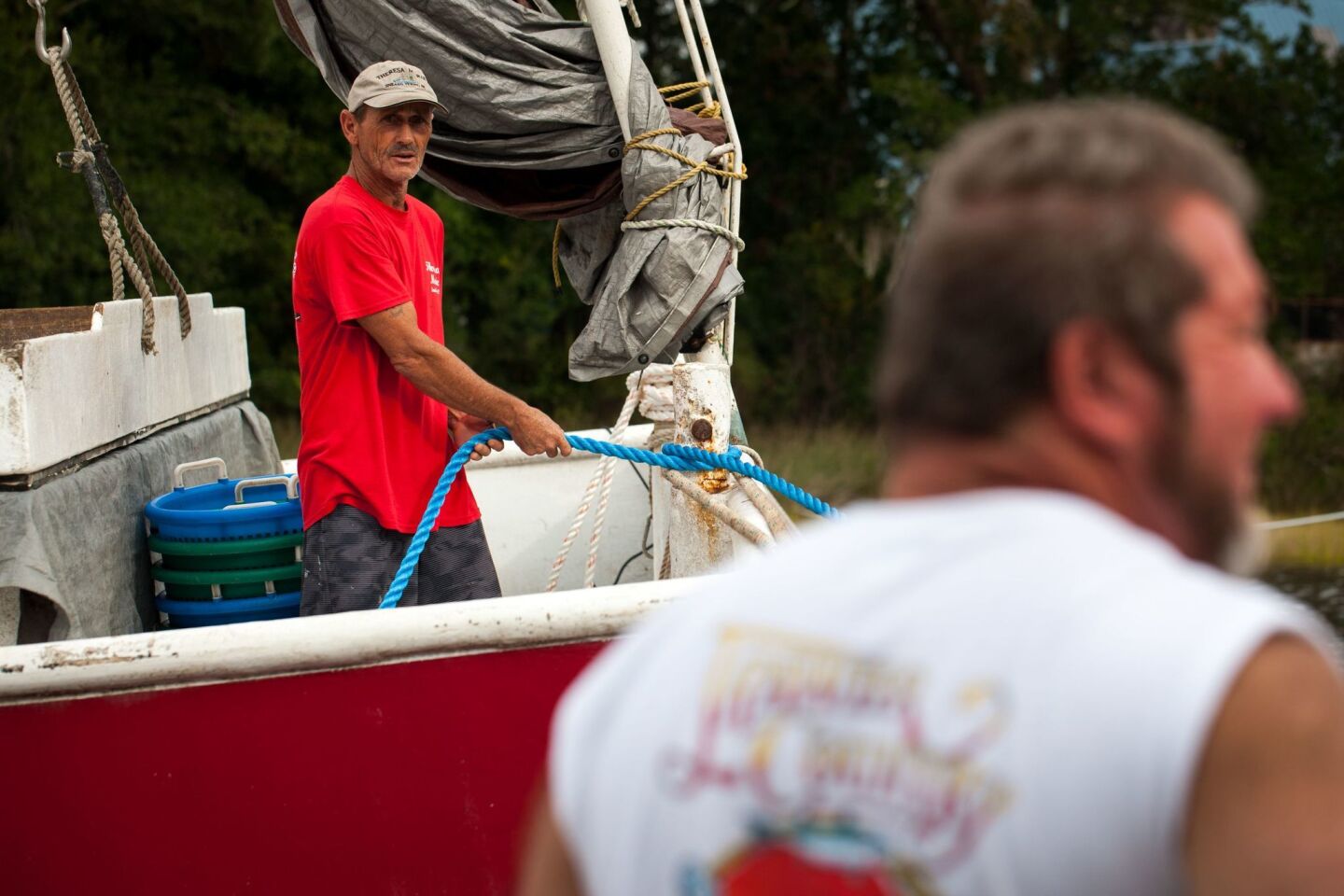 Crew members and boat owners help to moor the 'Miss Janice,' a shrimp boat, to the dock at Mitchell Seafood on Wheeler Creek in Sneads Ferry, North Carolina on September 13, 2018 in advance of Hurricane Florence. - Hurricane Florence edged closer to the east coast of the US Thursday, with tropical-force winds and rain already lashing barrier islands just off the North Carolina mainland. The huge storm weakened to a Category 2 hurricane overnight, but forecasters warned that it still packed a dangerous punch, 110 mile-an-hour (175 kph) winds and torrential rains.