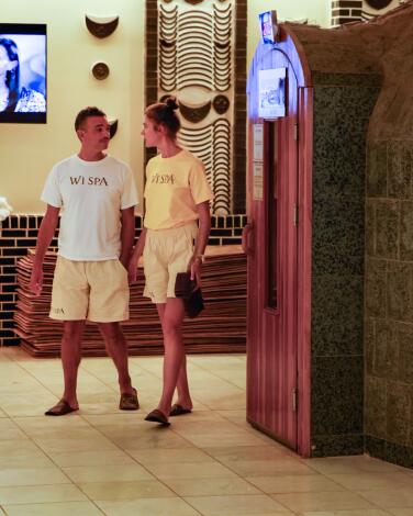 Two people in shorts walk in a spa.