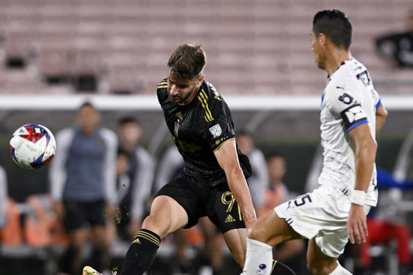 Los Angeles FC forward Mario González, left, shoots against Monterrey defender Héctor Moreno.