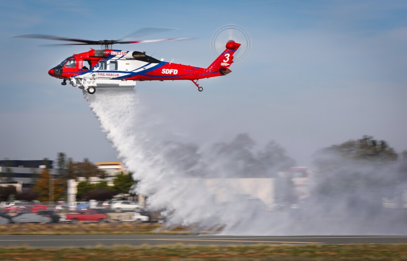 The S-70i Firehawk helicopter makes a demonstration water drop at Montgomery-Gibbs Executive Airport in Kearny Mesa, on Thursday. Called Copter 3, the San Diego Fire-Rescue Department chopper can hold up to 1,000 gallons of water with a total refill time of one minute.