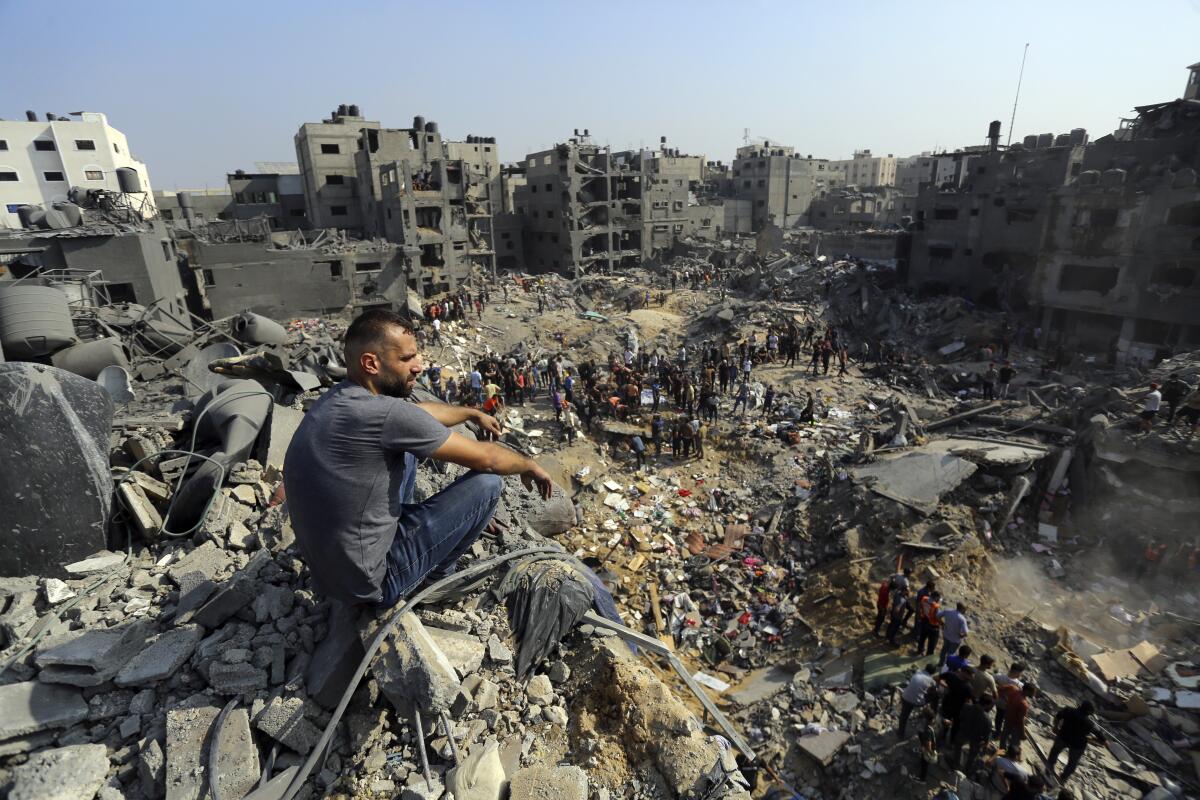 A man sits on the rubble among debris of buildings hit by Israeli airstrikes in Jabaliya refugee camp.