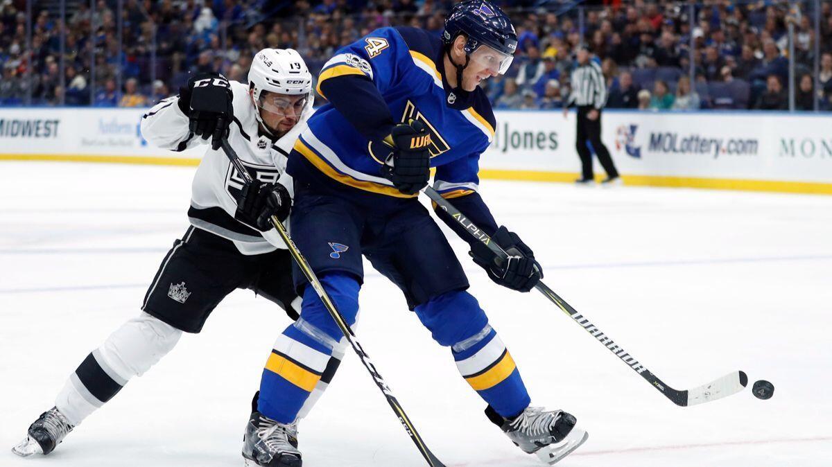 St. Louis Blues' Carl Gunnarsson, right, passes as Kings' Alex Iafallo defends during the first period on Monday.