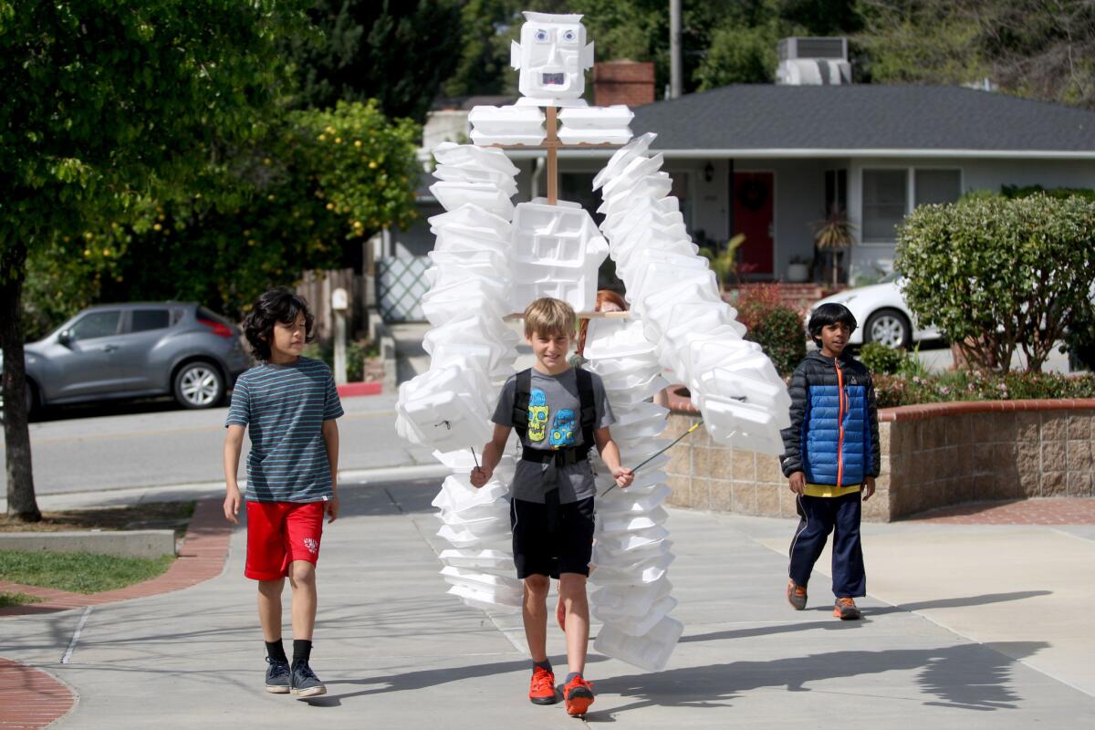 Styroman, carried by fifth-grader Sam Parks, and flanked by fifth-grader Isaac Reiter, left, and fourth-grader Om Mahesh, right, arrives at La Cañada Elementary School on Friday, March 4, 2016. Styroman was made from about 200 discarded lunch trays from the school's lunch program.