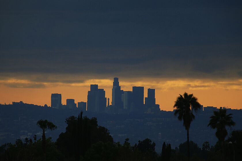 A view of downtown Los Angeles from the east, as the setting sun sillhouettes the city's skyline.